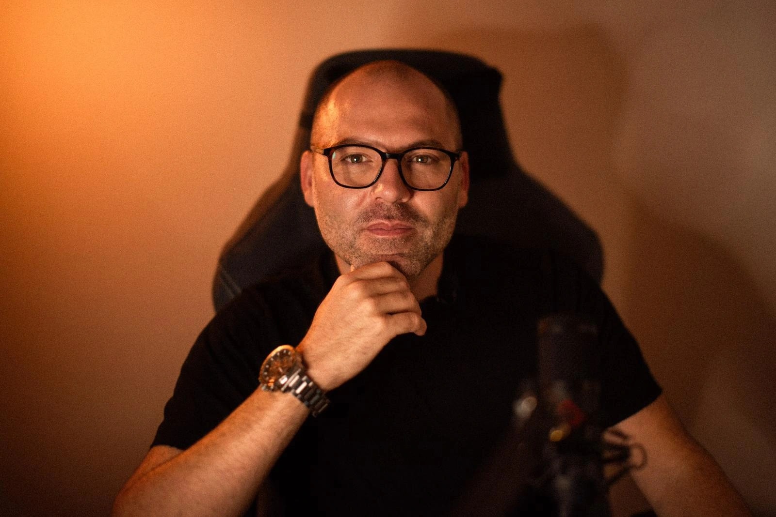 André Bacêlo e Costa no estúdio, sentado à secretária com microfone