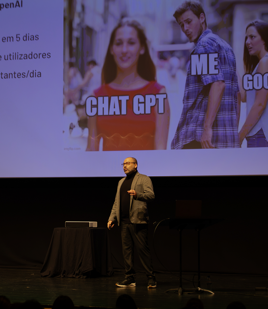 André F. Costa a ministrar uma palestra sobre o impacto do ChatGPT e IA, utilizando um meme popular para ilustrar a mudança de paradigma nas preferências tecnológicas.